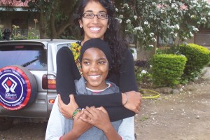 Supriya takes a picture with a smiling Tanzanian child. 