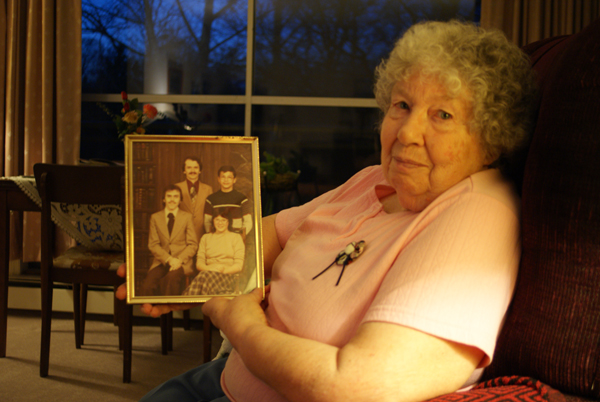 Joan Johnston holds a portrait of four of six children she raised with husband Ron.