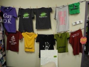 Consent awareness t-shirts from I Know Someone line the wall in the Peer Support office beneath the UCC.