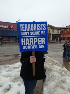 A protestor holds a sign while standing in Victoria Park on March 14th, 2015.  Photo by Sumayya Tobah.  