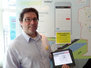 Jamie Skimming holds up a tablet showing an interactive map from reduceimpact.ca.