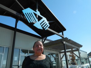 Traditional healer Liz Akiwenzie sits under the Thunderbird symbol at the Chippewas of the Thames S.O.A.H.A.C. site. 